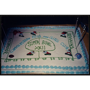 A shot of a cake commemorating Super Bowl XXII decorated with figurines and helmets