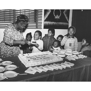 Elma Lewis serves cake to children at her celebration of 25 years of service