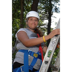 Nadia Alvarez on a ladder at the Torch Scholars Project Adventure Ropes Course