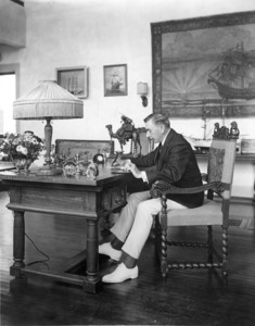 Portrait of Booth Tarkington, seated at a desk, facing left, Tarkington House, Kennebunkport, Maine, undated