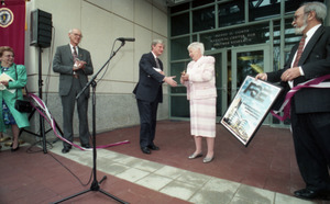 Dedication ceremonies for the Conte Polymer Center: David K. Scott shaking hands with Corinne Conte after the ribbon cutting, John Olver in background