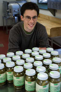 Young man seated in front of jars of Real Pickles pickles