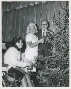 Margaret Milbank Bogert decorated a Christmas tree with a Virginia Granato, seated in a wheelchair.