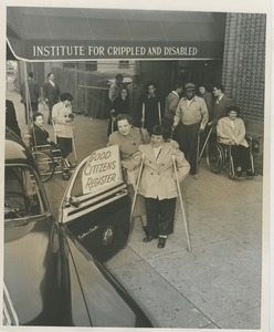 Clients on crutches and in wheelchairs on line under ICD awning