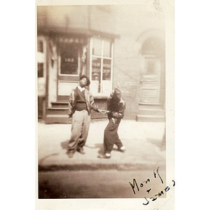 Monk and James pose in front of a barber shop on Hammond Street