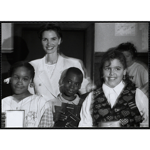 Heather Khan, a former news anchor, posing with a boy and two girls holding their awards at a Kiwanis Awards Night