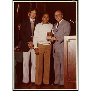 Brett Harris receives an award from Robert Cleary, Overseer of the Boys' Clubs of Boston, at right, and an unidentified man