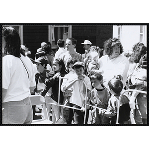 Several children stand in a line with two women behind them holding babies at the Boys and Girls Clubs of Boston 100th Anniversary Celebration Street Fair