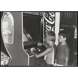 Two boys play a video game at a carnival