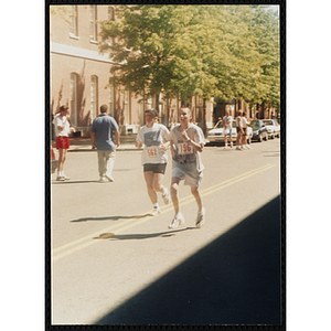 A woman and teenage boy run in the Battle of Bunker Hill Road Race