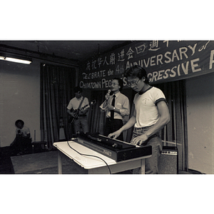 Three-man band performs on stage at the Chinese Progressive Association's Fourth Anniversary Celebration