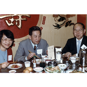 Henry Wong, Suzanne Lee, and guest eat at a restaurant table during a reception for the Consul General of Guangdong Province