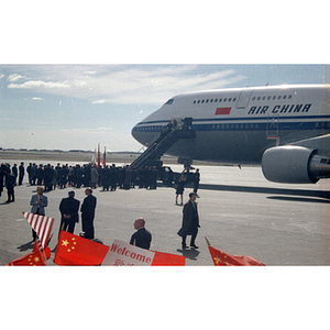 Zhu Rongji, Premier of the People's Republic of China, exits a plane at Boston Logan Airport to greet reporters and others in attendance to welcome him to Boston