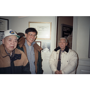 Chinese Progressive Association members at an unknown meeting, in front of a wall with veterans' honors