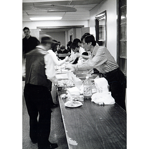 Man gets his food from a buffet table during a Thanksgiving dinner held at Association headquarters