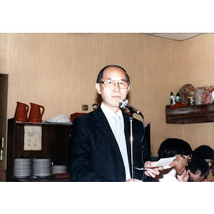 Henry Wong stands at a microphone