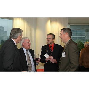 Four men in conversation at the Veterans Memorial dinner