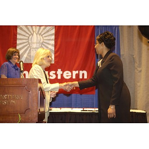 Melissa Owens and Karen T. Rigg shaking hands at the Student Activities Banquet