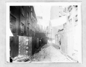 Alley with dirt piles and laundry hanging above