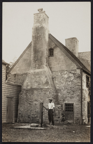 Portrait of unidentified man standing at hand pump, Spencer-Peirce-Little House, Newbury, Mass.