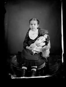 Portrait of a child seated with a doll