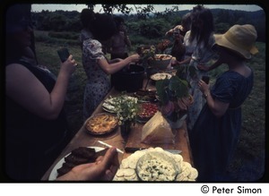 Women laying out food on a picnic table