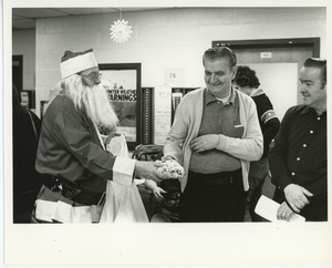 Santa Claus handing gifts to clients at Christmas party