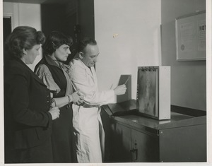 A doctor shows two women a spine x-ray