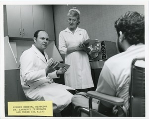 Dr. Lawrence Friedmann and nurse Ida Kling addressing a client in a wheelchair