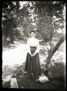 Young woman standing by tree (Greenwich, Mass.?)