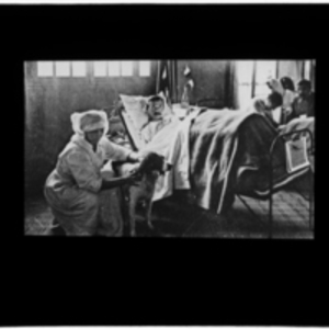 Patient in bed, attended by nurse and dog