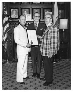 President Thomas A. Fulham and Representative Thomas McGee celebrate a commendation for Suffolk University for its free-tuition program for senior citizens from the Massachusetts State Legislature