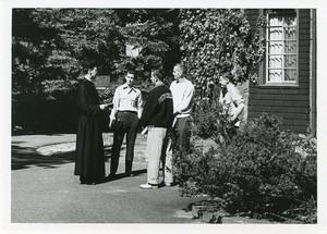 Saint Joseph's Hall exterior: side with priest and students talking close up