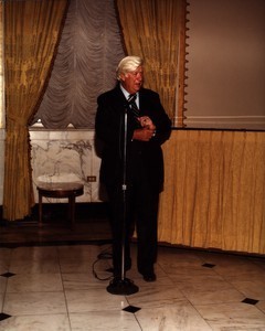 Thomas P. O'Neill speaking at a microphone, pulling at sleeve