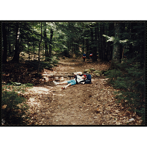 A boy with a backpack lies down on the Piper Trail