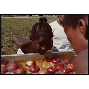 A girl bobs for apples during the Tri-Club Field Day at the Roxbury Clubhouse