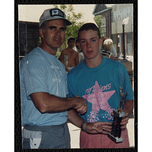 A man presents a teenage boy with a trophy during the Battle of Bunker Hill Road Race