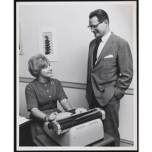 Elliot L. Richardson, at right, and an unidentified woman sitting at a typewriter