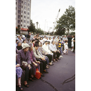 View of Chinatown residents seated and standing, facing right, at the Central Artery/Tunnel Project DD Ramp victory ceremony in Tai Tung parking lot, Boston