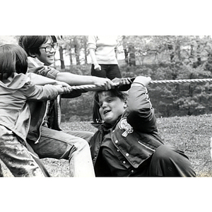 Young girls pull play tug-of-war at a tutoring class picnic
