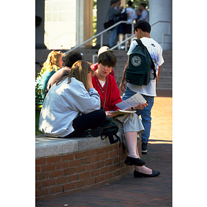 Three students speaking together in the Snell Library courtyard