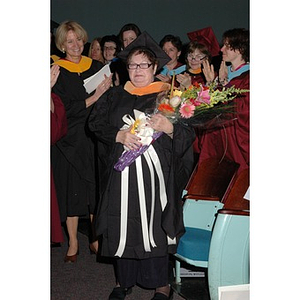 Faculty member poses with flowers at School of Nursing convocation