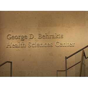 Signage for the George D. Behrakis Health Sciences Center in the Center's lobby