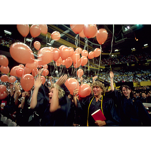 Class of 1995 graduates release balloons during the commencement ceremony