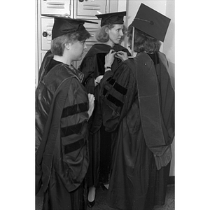 Law School graduates help each other get ready for commencement