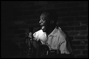 Josh White performing on guitar in a coffeehouse