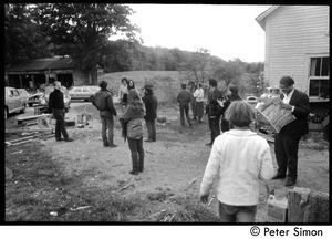 Members and friends of Packer Corners commune standing around outside the house