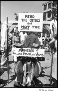 Sign at a Mobilization for Survival antinuclear demonstration near Draper Laboratory, MIT, reading 'Feed the cities and not the monster of nuclear power and arms'