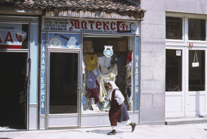 Woman passing storefront