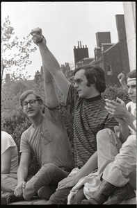 Demonstration at State House against the killings at Kent State: protesters seated on State House, raising fists